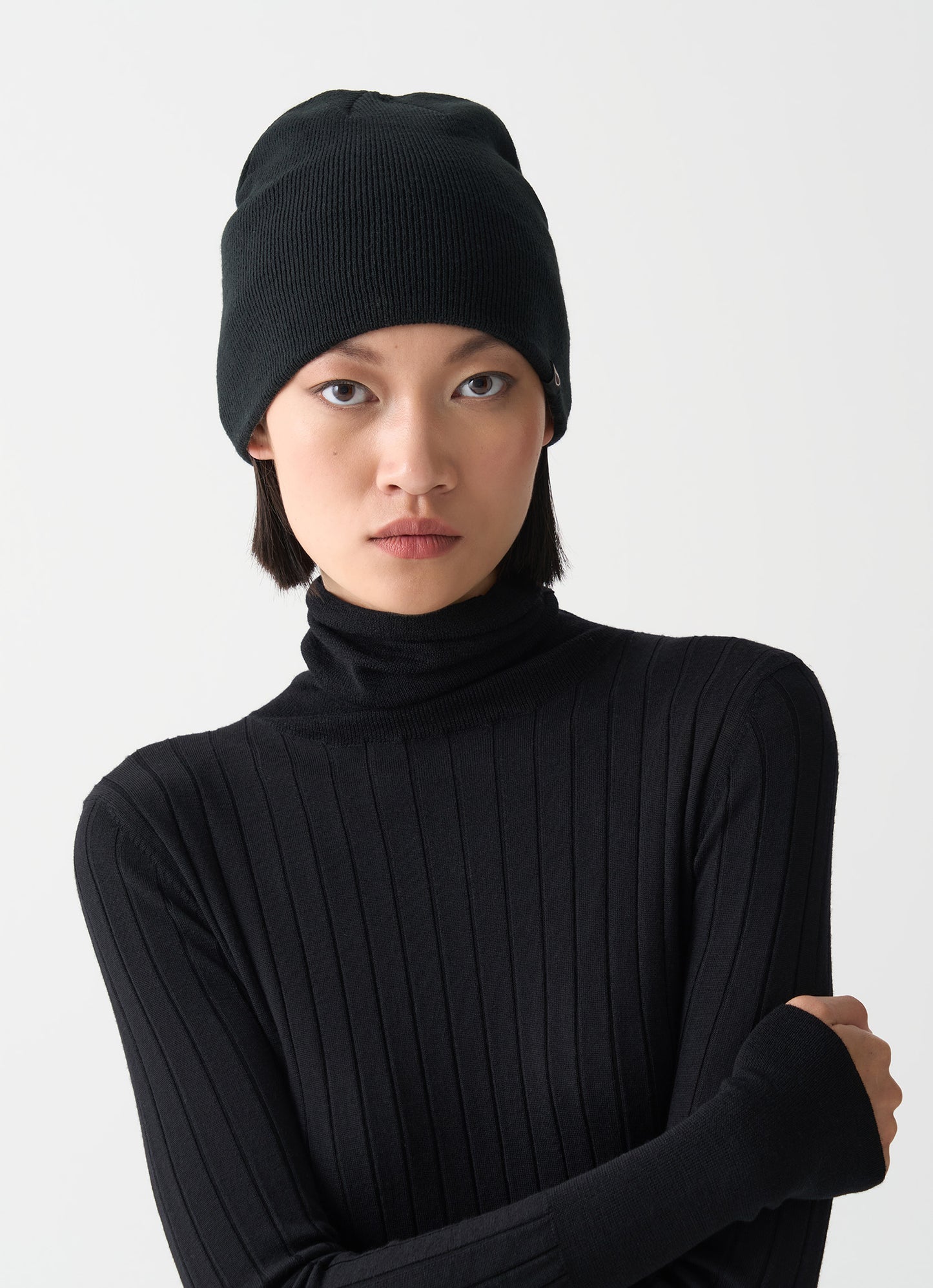 Cappello beanie unisex Colmar nero a costine con interno a contrasto e logo laterale indossato donna