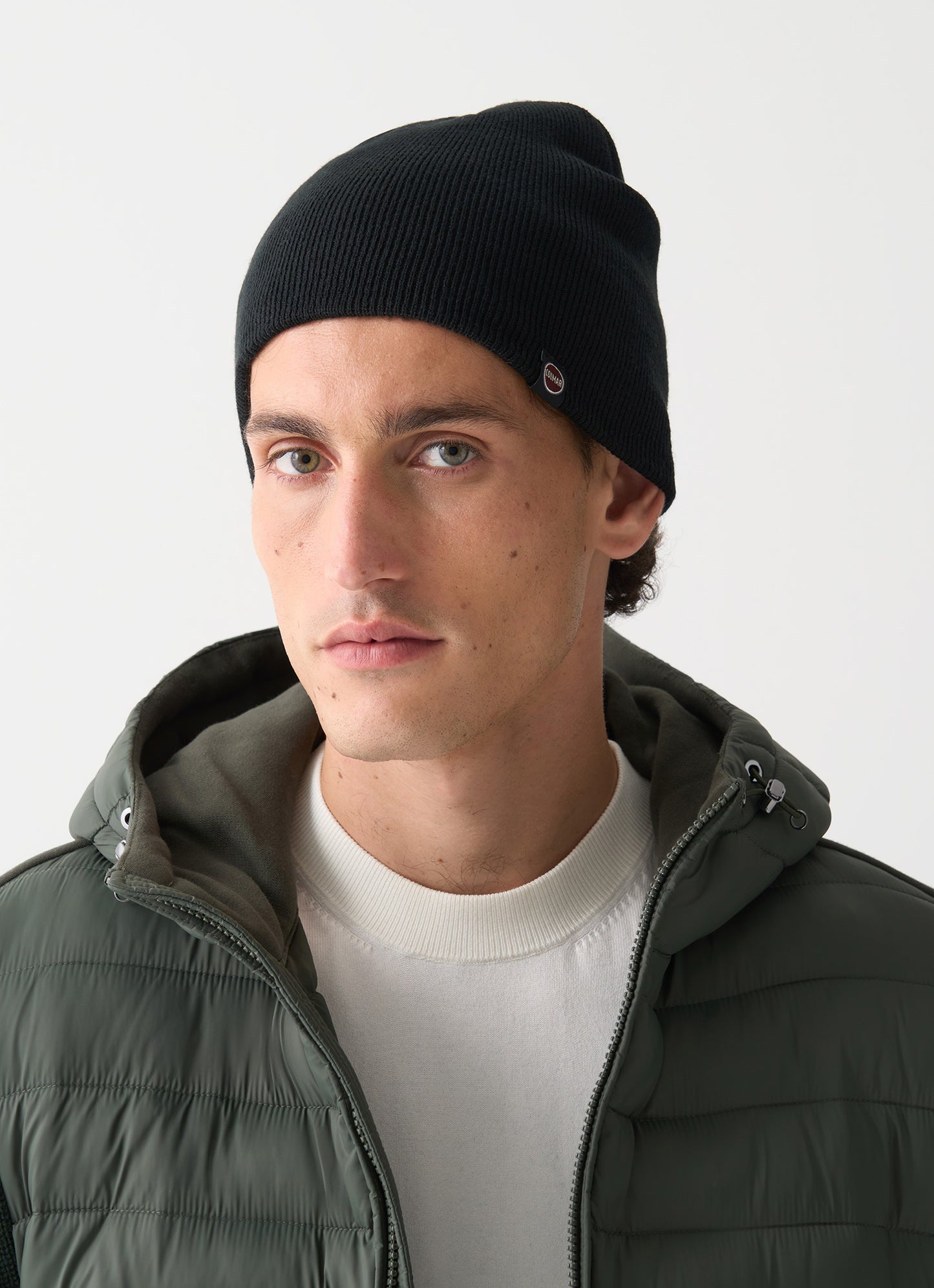 Cappello beanie unisex Colmar nero a costine con interno a contrasto e logo laterale indossato uomo