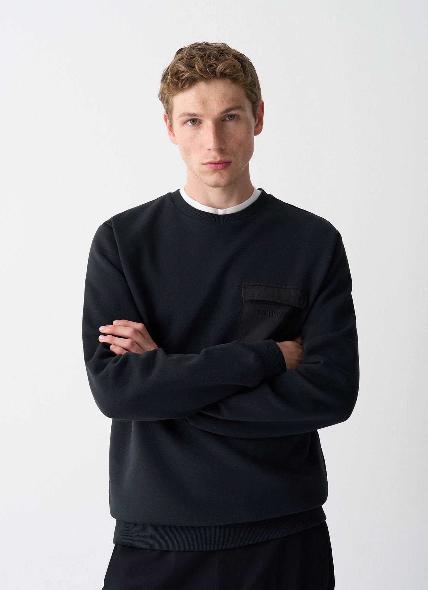 Felpa uomo Colmar Originals in cotone felpato nero con taschino in tessuto tecnico e logo gommato indossata davanti