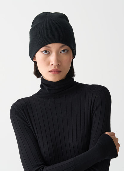 Cappello beanie unisex Colmar nero a costine con interno a contrasto e logo laterale indossato donna